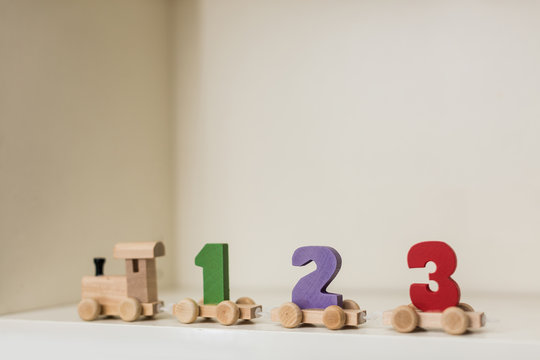children's toy steam locomotive made of wood stands on the table numbers 1 2 3 in a row