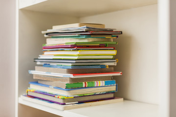 a shelf with a stack of colorful books on a bright day