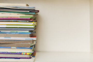 a shelf with a stack of colorful books on a bright day