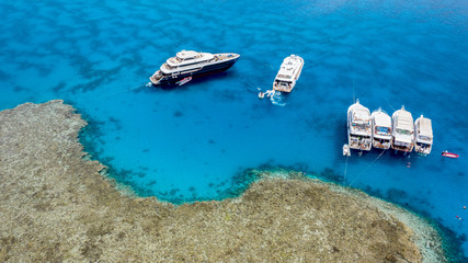 Aerial view: Boats parked on a coral reef in the Red Sea, Egypt.