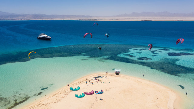 Aerial view of a yacht and a beautiful island and many kitesurfers on the Red Sea in Egypt