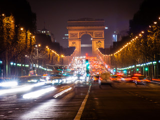 Fototapeta na wymiar Arc de Triomphe and Champs-Elysees Trump Arch in Paris at night with headlights and cars