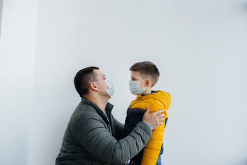 A father with his child stands in a mask during the quarantine. Pandemic, coronavirus