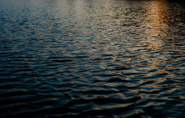 Close-up of the water surface of the lake. Sun reflecting on the water. Beautiful sunset. Nokhur Gol Lake, Qabala, Azerbaijan © Klavdiya22