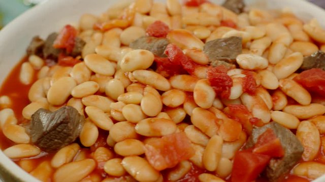 Close-up of haricot bean stew with meat in tomato sauce