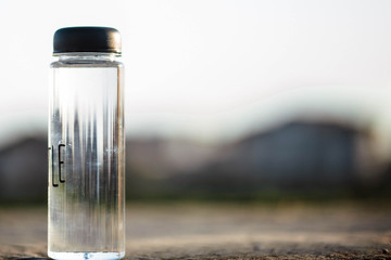 Water bottle. Mug. Water bottle lying on concrete and behind it a blurred background. Coffee. It's time to drink a donut. Water.