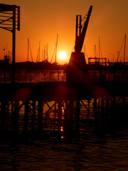 Fototapeta na wymiar Harbor silhouette at stunning sunset.