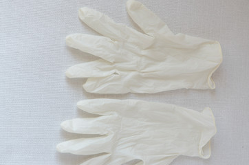 Obraz premium Medical glove, protection of hands from infections. White disposable glove on a gray background.