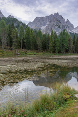 Fototapeta na wymiar Italian Dolomites reflecting on the lake of Antorno on a cloudy autumn day