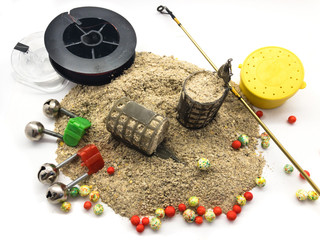 Bait feeder, fishing rod, fishing line, fish bait, jar for worms, bells  and plastic bait isolated on white background. Composition of tools for professional fishing. Set of fishing tackle. 