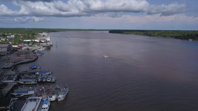Drone aerial view of Breves city, Para, Brazil. Streets, houses and river with wooden boats on sunny summer day in the Amazon rainforest. Concept of environment, ecology, travel and climate change.4K.