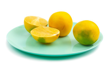 two whole and two halves of yellow-green grapefruit on a white background, isolate