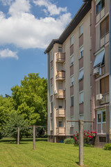 Facade of a decently renovated socialistic type city block. Fresh walls and paint on a city block make it alnist brand new. Clothes line in foreground.