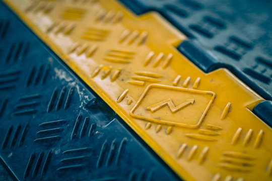 Black and yellow plastic cable protector on the ground. Floor cable protector with plastic cover. Cable saver on an event in high visibility colors.