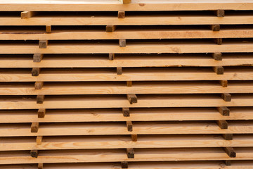 Warehouse for sawing boards on a sawmill outdoors. Timber mill, sawmill. Storage of planed wooden boards. Piles of wooden boards in the sawmill. Planking. Industry.
