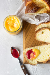Challah bread or cozonac on a wooden board, light grey stone background. Shabbat, Jewish traditional bread. Easter bakery. Top view.