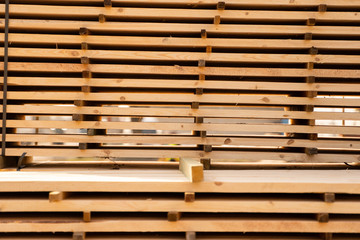 Warehouse for sawing boards on a sawmill outdoors. Timber mill, sawmill. Storage of planed wooden boards. Piles of wooden boards in the sawmill. Planking. Industry.
