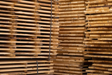 Warehouse for sawing boards on a sawmill outdoors. Timber mill, sawmill. Storage of planed wooden boards. Piles of wooden boards in the sawmill. Planking. Industry.