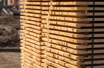 Warehouse for sawing boards on a sawmill outdoors. Timber mill, sawmill. Storage of planed wooden boards. Piles of wooden boards in the sawmill. Planking. Industry.