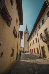 Fototapeta na wymiar The streets of old town in venzone, italy, looking towards beautiful belltower rising high up.