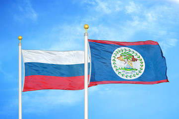 Russia and Belize  two flags on flagpoles and blue cloudy sky