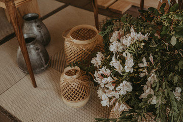 Decoracion de hogar con cestas de mimbre, flores y telas con motivos.