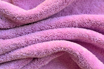 Soft fabric background. Terry towel, close-up. Soft fabric of pink, lilac colors. Texture.
