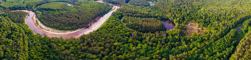 View of the river flowing through the forest. Aerial photography