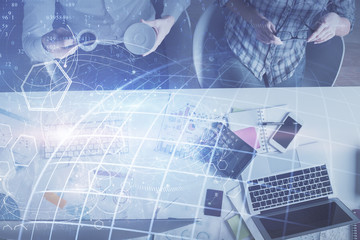 Double exposure of man and woman working together and world map hologram drawing. international network concept. Computer background. Top View.