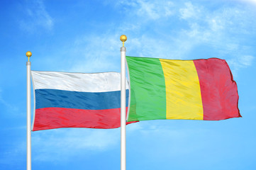 Russia and Mali two flags on flagpoles and blue cloudy sky