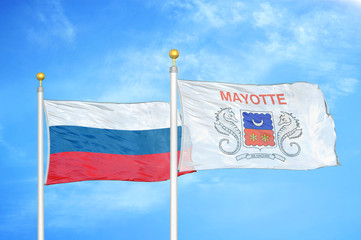 Russia and Mayotte two flags on flagpoles and blue cloudy sky