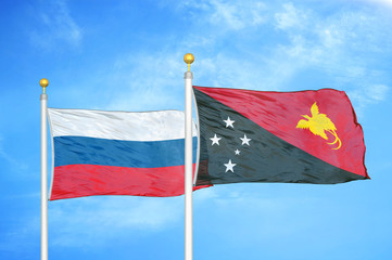 Russia and Papua New Guinea two flags on flagpoles and blue cloudy sky