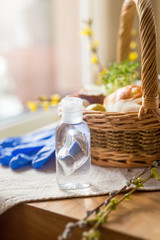 Easter basket in coronavirus pandemic with bottle of hand sanitizer gel and protevtive gloves