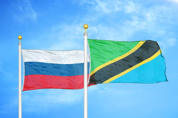 Russia and Tanzania two flags on flagpoles and blue cloudy sky