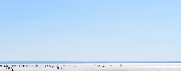 Silhouette of a lot of people at the Salt Lake taking pictures and enjoying the view of infinity