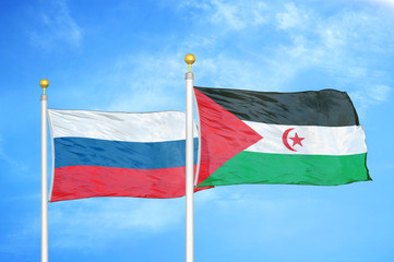 Russia and Western Sahara two flags on flagpoles and blue cloudy sky