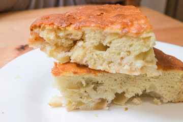 Sweet homemade cakes with apples. Two slices of sponge Apple pie with a brown crust on a white plate close up