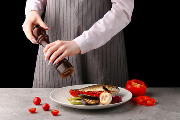 the chef is cooking grilled vegetables. pepper. female hands of the chef. on a black background