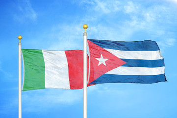 Italy and Cuba two flags on flagpoles and blue cloudy sky