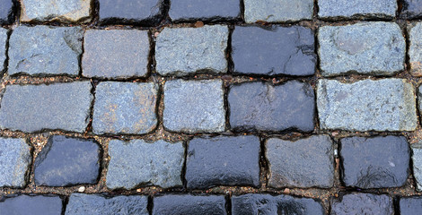 A fragment of a stone paved road. Background, masonry.