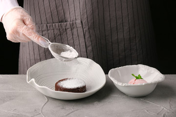White plate with chocolate fondant close up. woman hands. chef make dessert. Lava cake recipe
