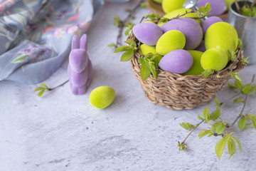 easter green and purple eggs with rabbit on a light surface