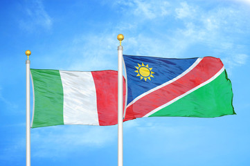 Italy and Namibia two flags on flagpoles and blue cloudy sky