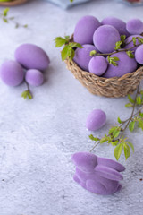 easter green and purple eggs with rabbit on a light surface