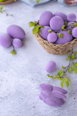 easter green and purple eggs with rabbit on a light surface