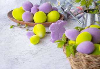 Obraz na płótnie Canvas easter green and purple eggs with rabbit on a light surface