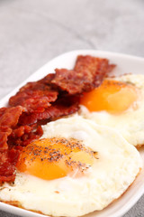 fried egg with bacon on plate. breakfast concept. close up