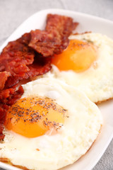 fried egg with bacon on plate. breakfast concept. close up