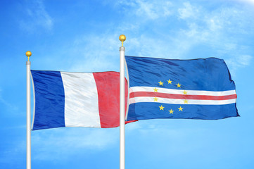 France and Cape Cabo Verde  two flags on flagpoles and blue cloudy sky