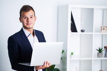 Solid businessman in a jacket works in office of company.